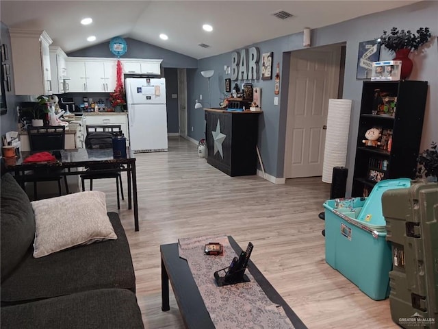 living room with light hardwood / wood-style floors and lofted ceiling