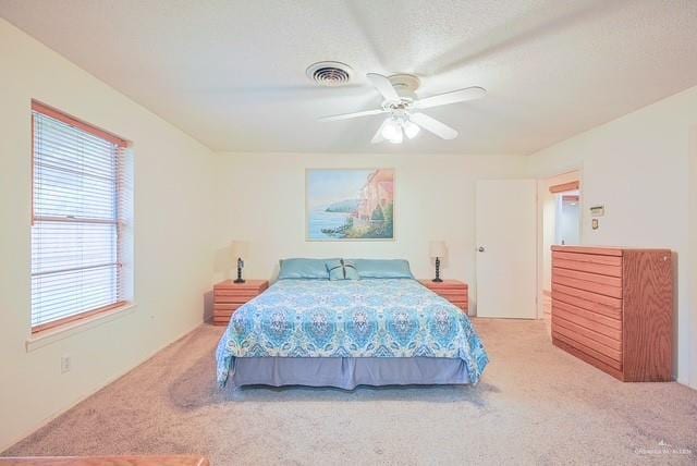 bedroom with visible vents, a ceiling fan, and carpet