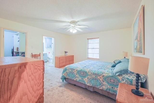 bedroom with carpet floors, ceiling fan, and connected bathroom