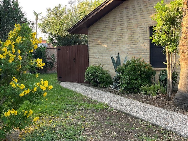 view of home's exterior with brick siding and fence