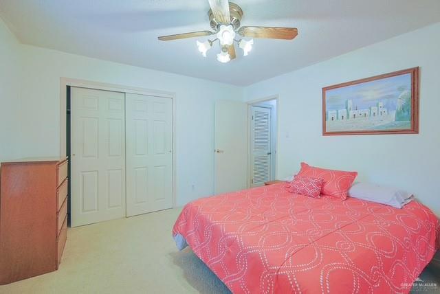 carpeted bedroom featuring a closet and ceiling fan