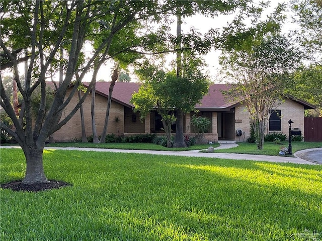 ranch-style house with brick siding and a front yard