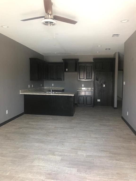 kitchen with light wood-style flooring, visible vents, light countertops, and baseboards