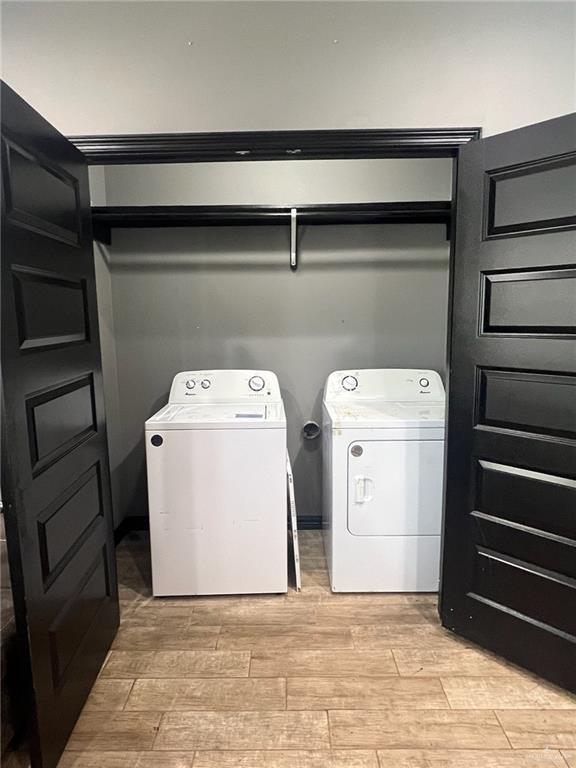 washroom featuring laundry area, wood tiled floor, and independent washer and dryer