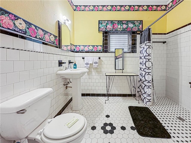 bathroom with tile patterned floors, toilet, walk in shower, and tile walls