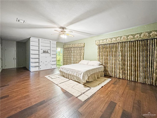 bedroom featuring a textured ceiling, dark hardwood / wood-style floors, ceiling fan, and billiards