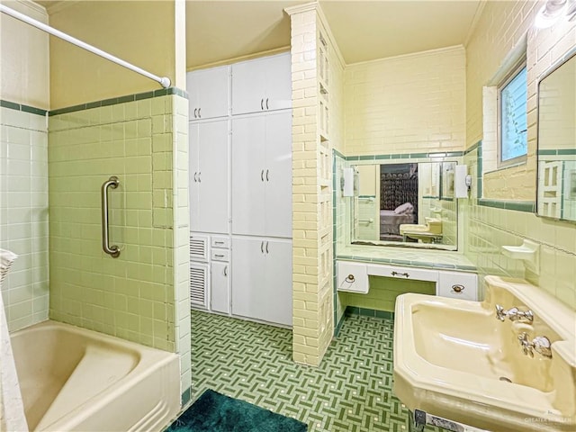 bathroom featuring sink, tiled shower / bath combo, tile walls, and ornamental molding