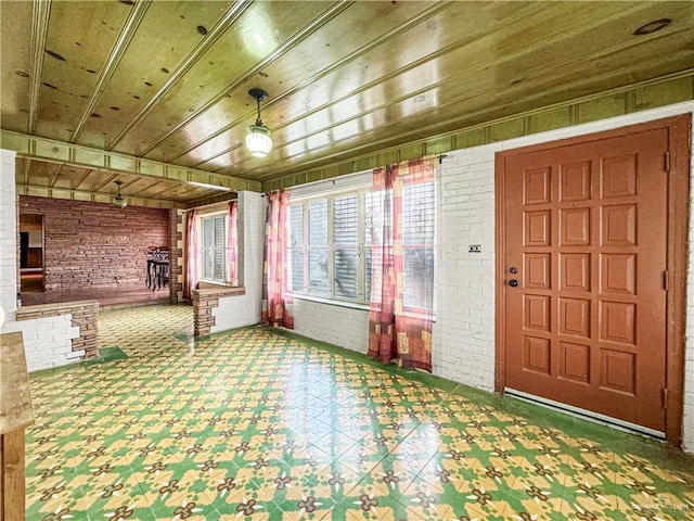 entryway with wood ceiling and brick wall