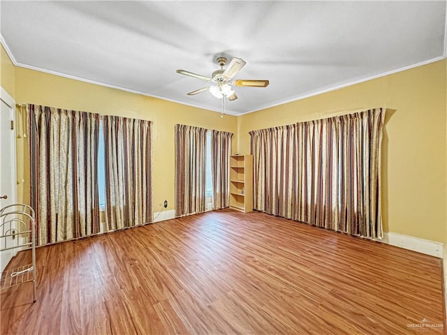 unfurnished room featuring hardwood / wood-style floors, ceiling fan, and crown molding