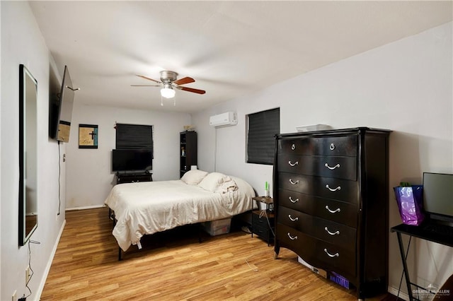 bedroom with ceiling fan, a wall unit AC, and light wood-type flooring