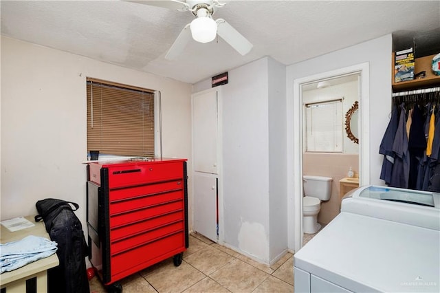 interior space with ceiling fan, independent washer and dryer, and light tile patterned floors