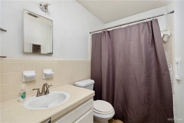 bathroom with vanity, a shower with shower curtain, tile walls, and toilet