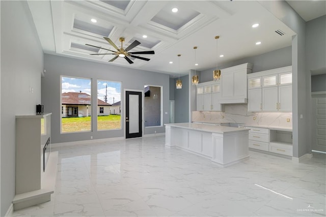 kitchen featuring coffered ceiling, pendant lighting, white cabinetry, a center island, and beamed ceiling