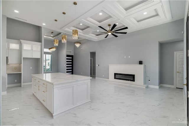 kitchen featuring pendant lighting, white cabinets, a center island, coffered ceiling, and beam ceiling