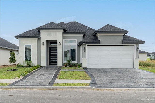 prairie-style house with a garage and a front lawn