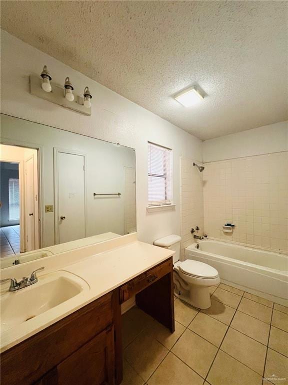 full bathroom with tile patterned floors, vanity, a textured ceiling, tiled shower / bath combo, and toilet