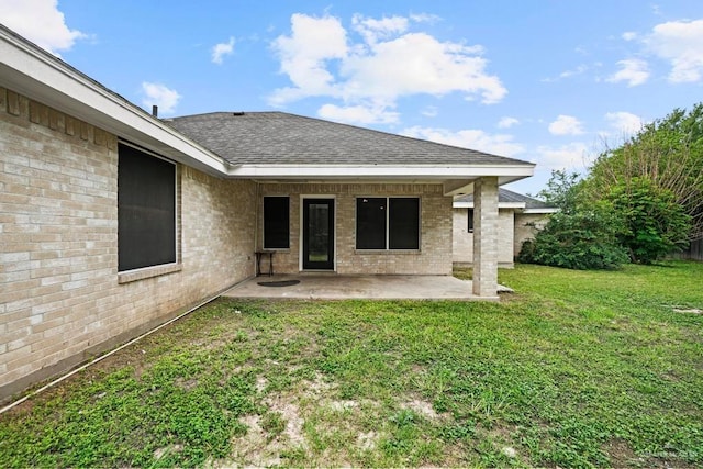1315 Rio Guadalupe Cir, San Juan, TX 78589 - back of house with a lawn, a shingled roof, a patio, and brick siding