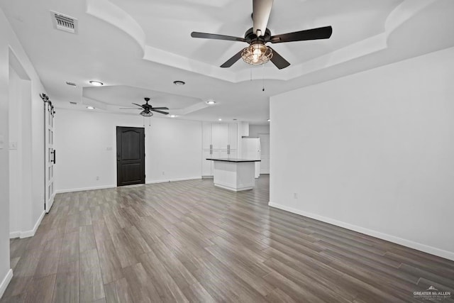 1315 Rio Guadalupe Cir, San Juan, TX 78589 - unfurnished living room with visible vents, a raised ceiling, ceiling fan, and wood finished floors