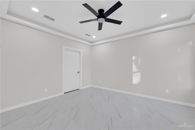 spare room featuring a tray ceiling and ceiling fan