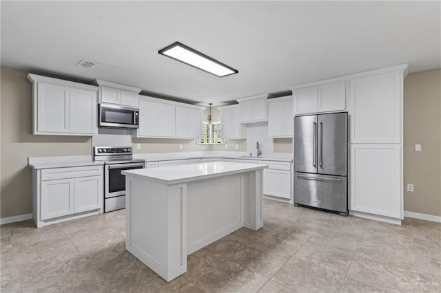 8006 Senecio St, Mission, TX 78574 - kitchen featuring stainless steel appliances, a kitchen island, light countertops, and white cabinets
