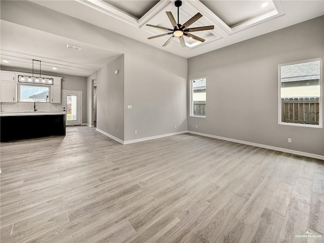 612 Yoli Ln, Donna, TX 78537 - unfurnished living room featuring coffered ceiling, light wood-type flooring, baseboards, beamed ceiling, and plenty of natural light