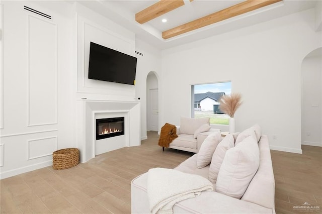 living room with light hardwood / wood-style flooring and beamed ceiling