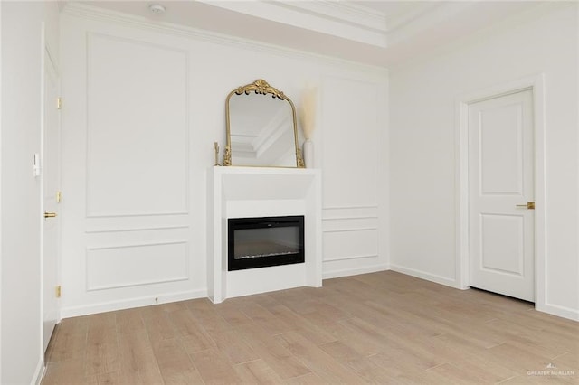 unfurnished living room with ornamental molding and light wood-type flooring