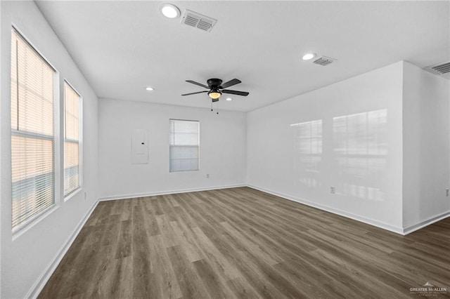 unfurnished room with dark hardwood / wood-style floors, a healthy amount of sunlight, and ceiling fan