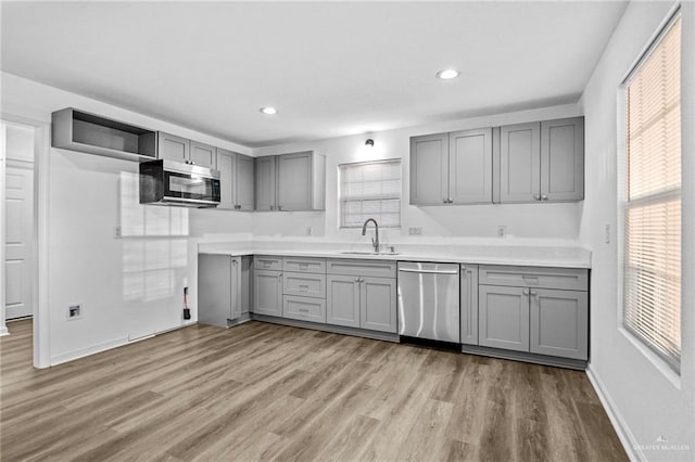 kitchen featuring gray cabinets, stainless steel appliances, light hardwood / wood-style flooring, and sink