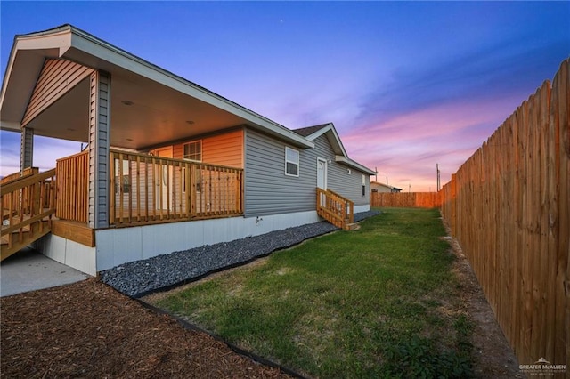 property exterior at dusk featuring a yard