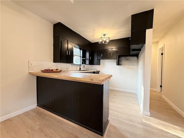 603 Witmer St, Weslaco, TX 78596 - kitchen with dark cabinetry, a peninsula, and light wood-type flooring