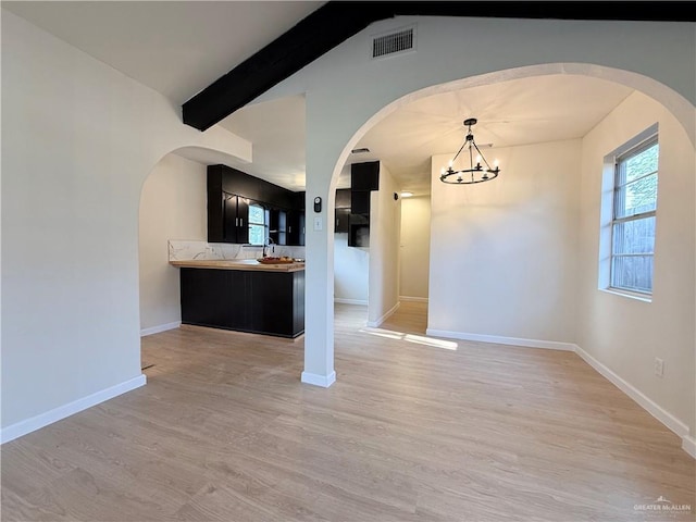 603 Witmer St, Weslaco, TX 78596 - unfurnished dining area featuring arched walkways, a chandelier, and light wood-style flooring