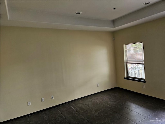 spare room with a tray ceiling