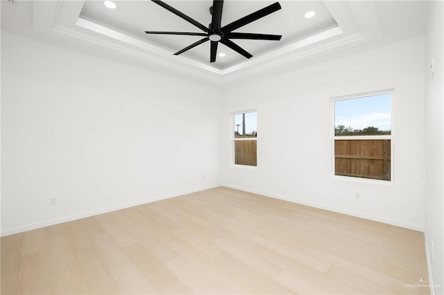 unfurnished room with a tray ceiling, light hardwood / wood-style flooring, and ceiling fan