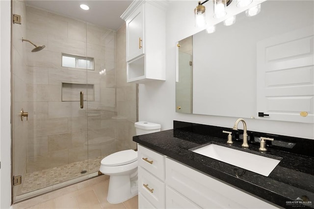 bathroom featuring tile patterned floors, vanity, walk in shower, and toilet