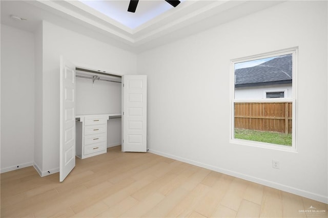 unfurnished bedroom featuring ceiling fan, light wood-type flooring, and a closet