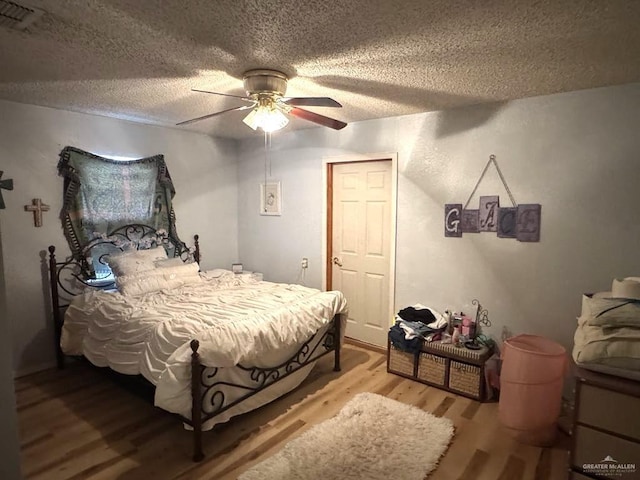 1308 E 2nd St, Weslaco, TX 78596 - bedroom with wood finished floors, a textured ceiling, and a ceiling fan