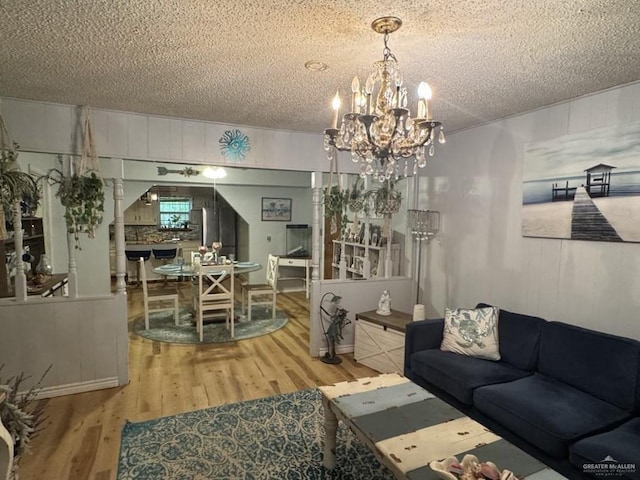 1308 E 2nd St, Weslaco, TX 78596 - living room with a textured ceiling, a chandelier, and wood finished floors