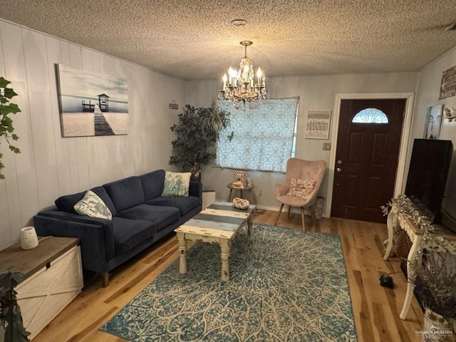 1308 E 2nd St, Weslaco, TX 78596 - living area featuring wood finished floors, a chandelier, a textured ceiling, and wooden walls