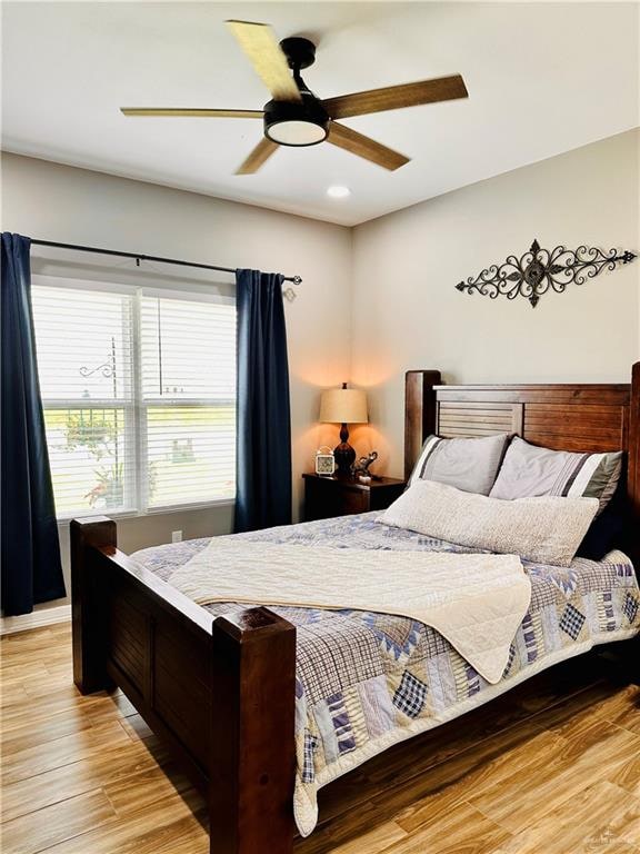 bedroom with ceiling fan and light hardwood / wood-style flooring