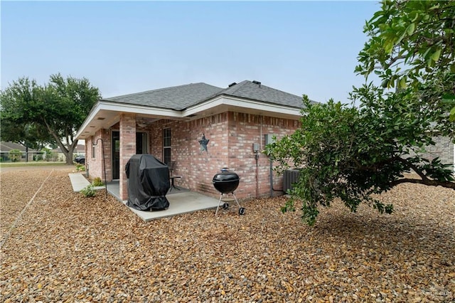 512 Mercury St, Mission, TX 78572 - back of house with a patio area, brick siding, roof with shingles, and cooling unit