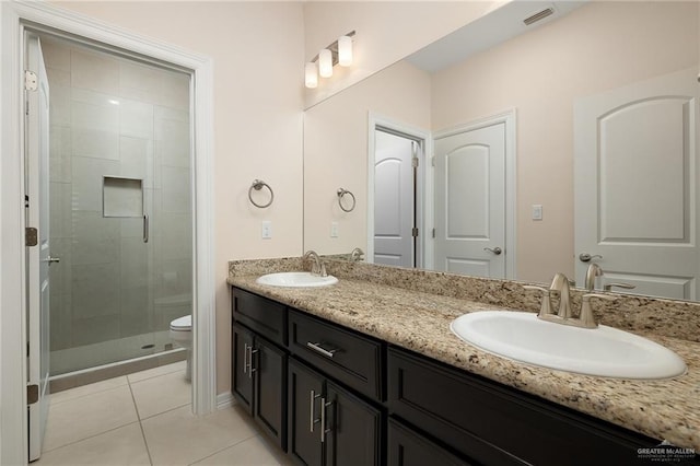 bathroom with toilet, vanity, tile patterned floors, and an enclosed shower