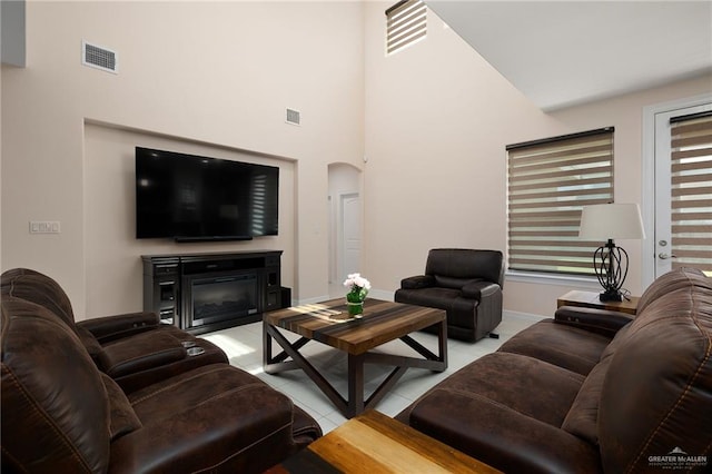 tiled living room with a towering ceiling