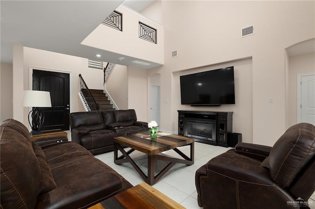 living room with light tile patterned floors and a high ceiling