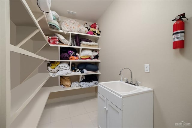 washroom with light tile patterned flooring and sink