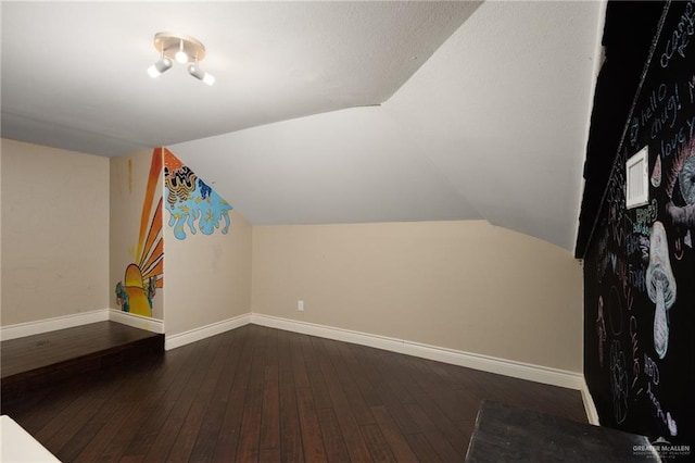 bonus room with dark hardwood / wood-style flooring and vaulted ceiling