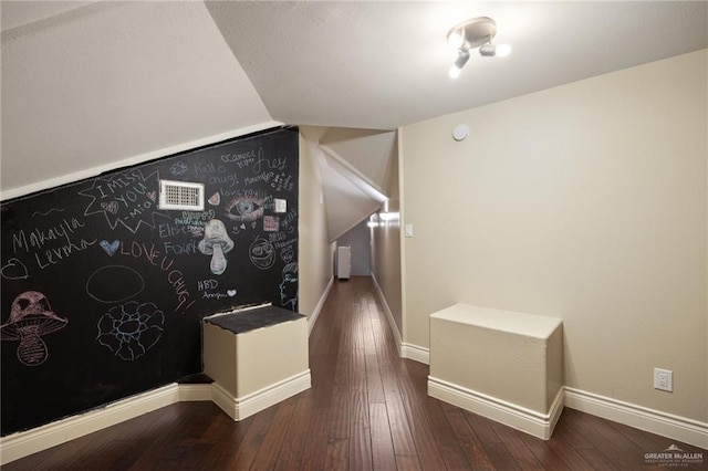 hall featuring hardwood / wood-style floors and vaulted ceiling