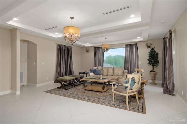 tiled living room with a raised ceiling and a notable chandelier