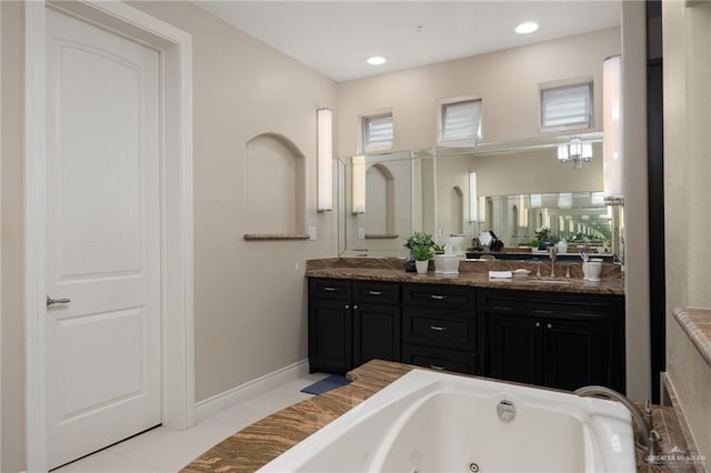 bathroom with tile patterned flooring, vanity, and a tub to relax in