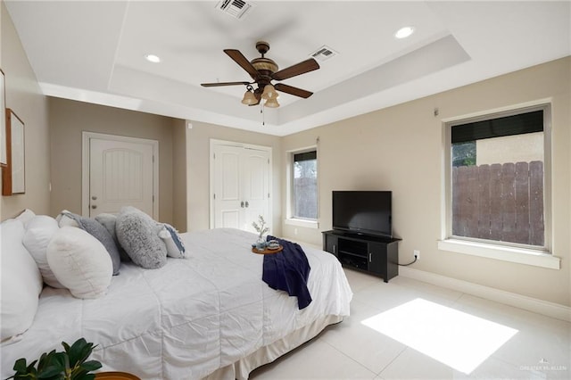 bedroom with a raised ceiling and ceiling fan